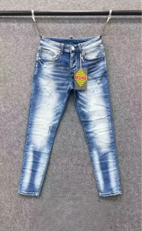 Jean homme dans un denim bleu délavé avec des effets de blanchiment subtils.