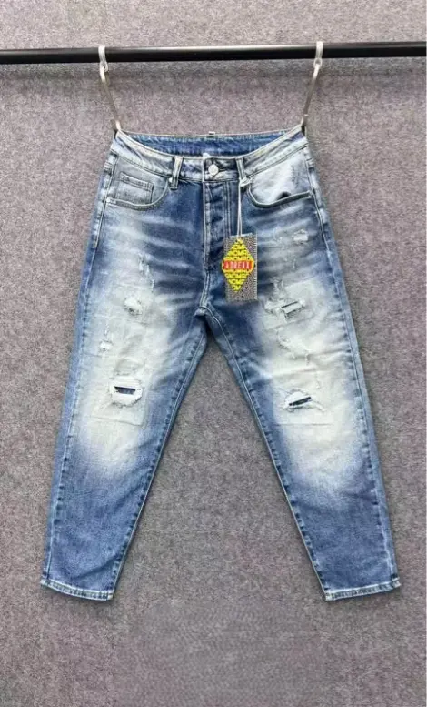 Jean homme en denim bleu clair délavé avec des effets blanchis sur l’avant pour un rendu moderne, déchirures légères et finitions usées