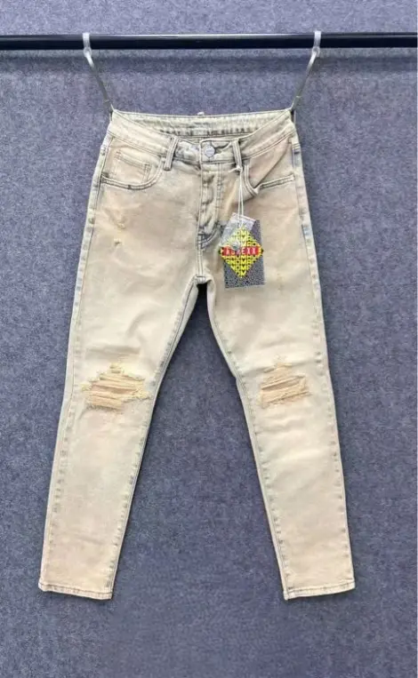 Jean homme en denim bleu et beige clair délavé pour un rendu doux et tendance,déchirures discrètes au niveau des genoux