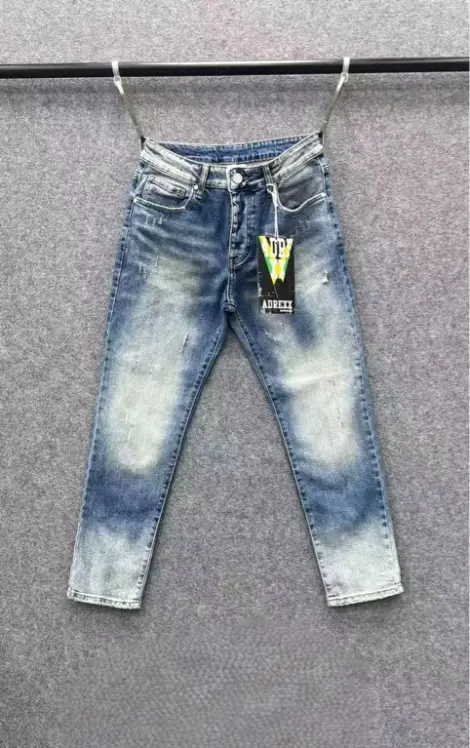 Jean homme en denim bleu moyen délavé avec des effets de blanchiment marqués sur l’avant.