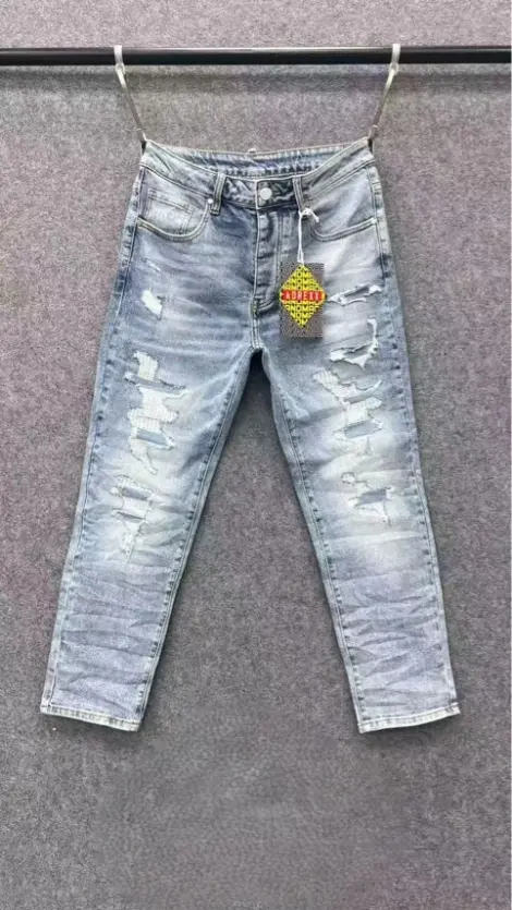 Jean homme en denim gris clair délavé, déchirures travaillées et d’effets usés sur l’avant